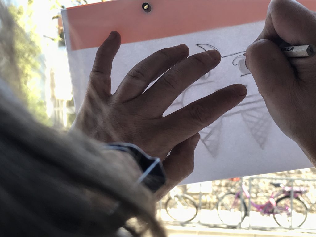 Développer sa créativité. Deux main, un crayon et une feuille à dessin.